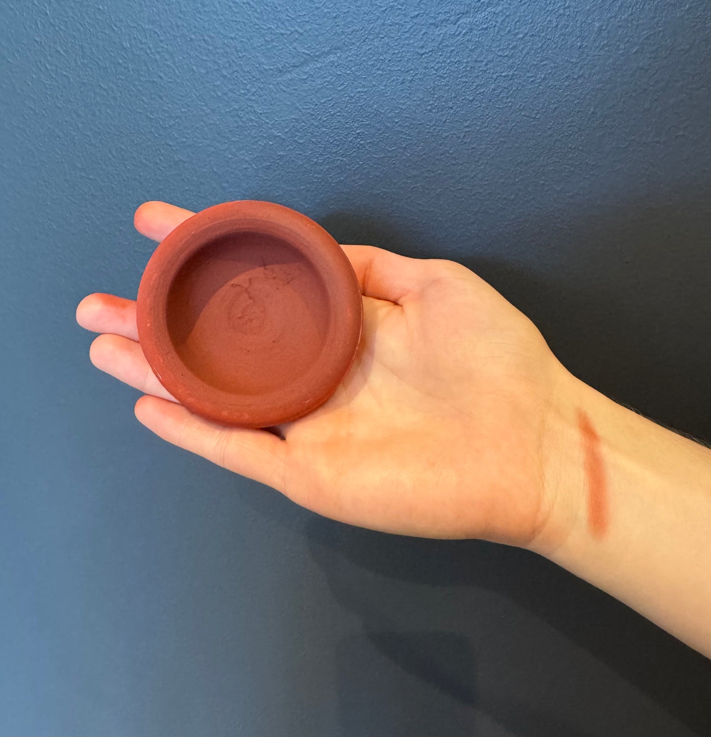 Intérieur du tagine Aker Fassi vu de haut, révélant la couleur rouge intense de la poudre 100 % naturelle à base de fleurs séchées.