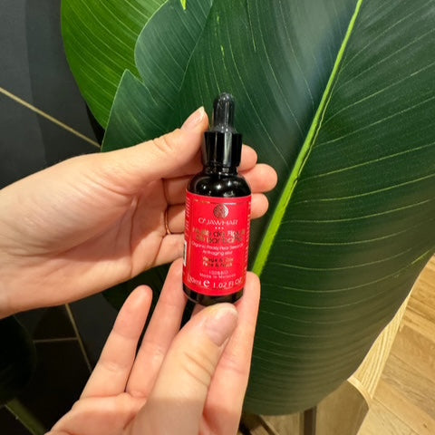 Huile de figue de barbarie O’Jawhar tenue en main devant des feuilles – soin bio certifié ECOCERT pour visage, cou et cheveux – anti-âge naturel et pressée à froid