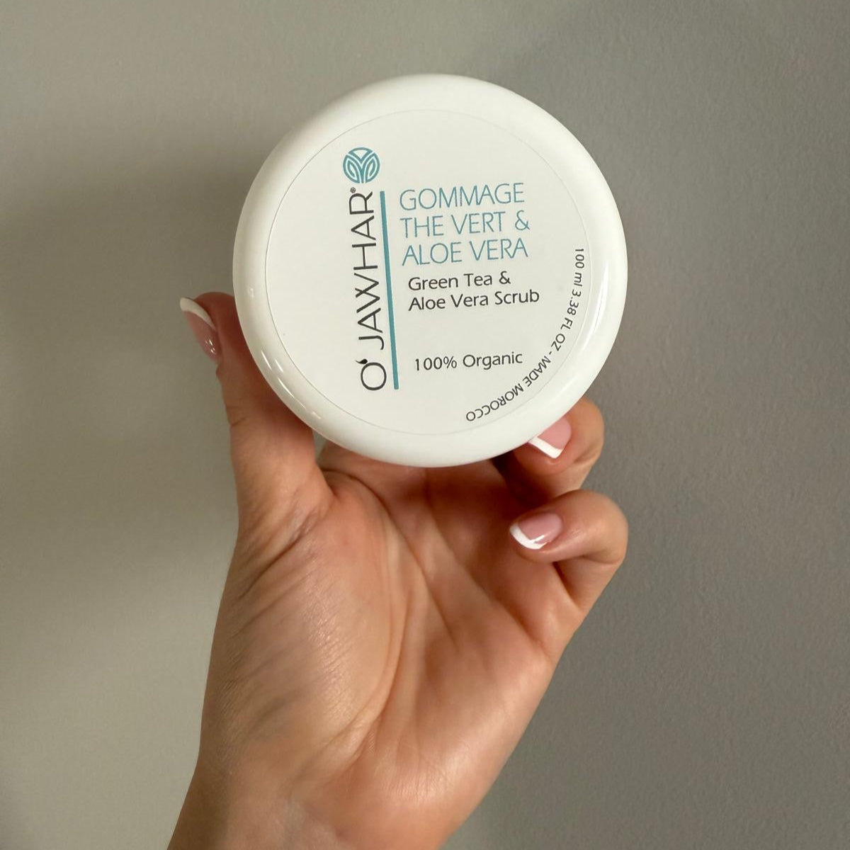 Gommage O’Jawhar tenu à la main – soin purifiant doux au thé vert et aloe vera.
