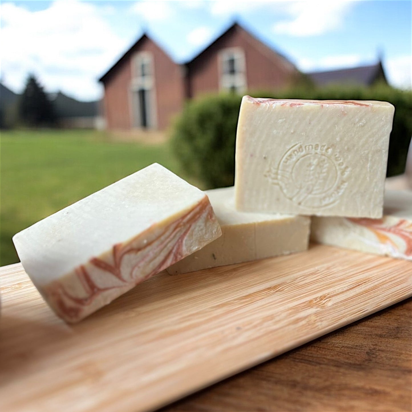 Savon à l’argan O’Jawhar sans étiquette visible, mis en valeur à l’extérieur devant une maison en bois.