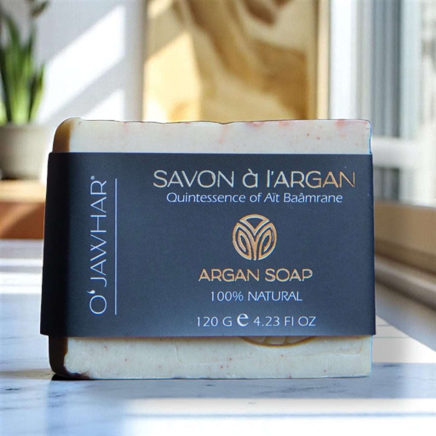 Savon à l’argan O’Jawhar – Vue en intérieur, marbrures naturelles et étiquette noire élégante.