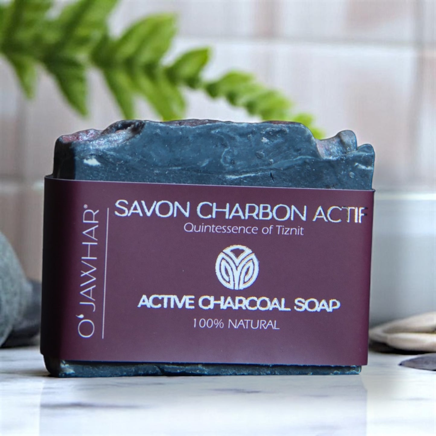 Savon Charbon Actif O’Jawhar posé dans une salle de bain élégante — savon naturel purifiant au charbon inspiré de Tiznit, 100 % naturel.