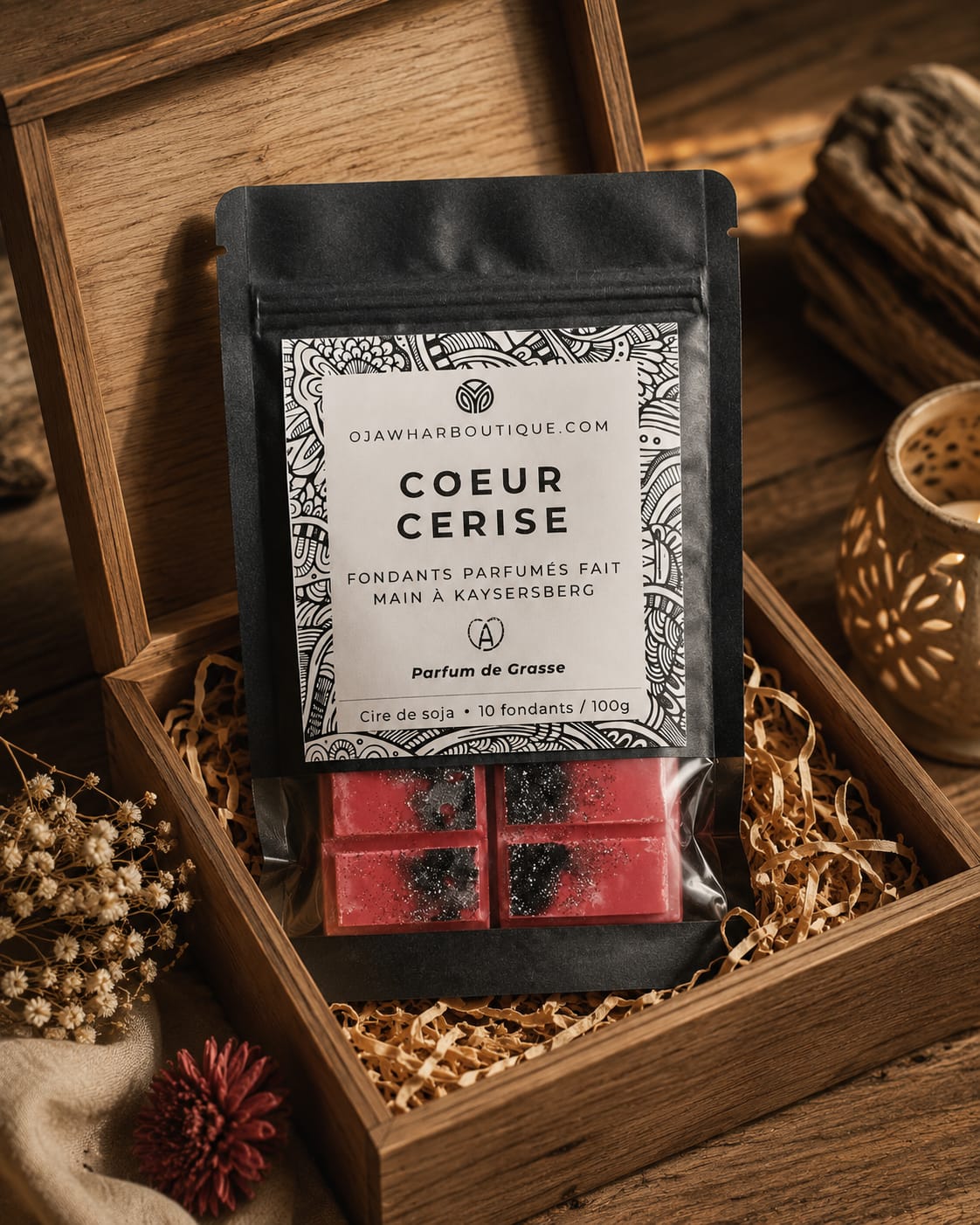Sachet de fondant parfumé O'Jawhar Cœur Cerise posé dans un coffret en bois avec des fondants parfumés.