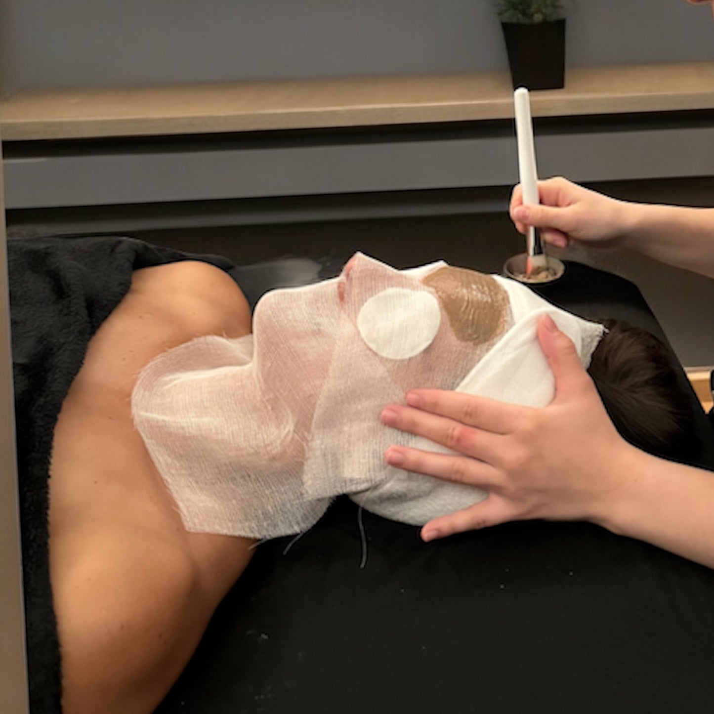 Application d'un masque au rhassoul et à l'huile d'argan O'Jawhar lors d'un soin visage en institut