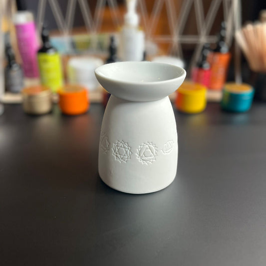 Brûleur à fondant parfumé en céramique décoré de signes de bien-être, vue de face.