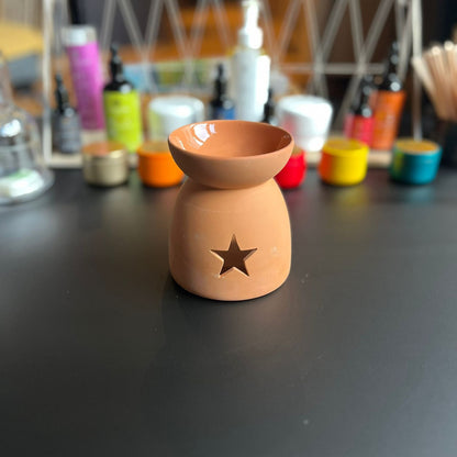 Brûleur à fondant en céramique effet terre cuite vu de face, design étoile, diffuseur pour fondants parfumés.