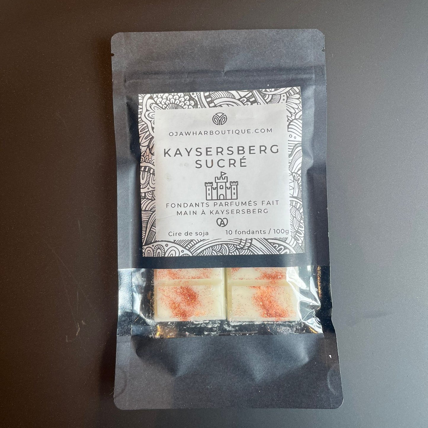 Sachet noir contenant 10 carrés de fondant Kaysersberg Sucrée, parfum casse-noisette, décor micra marron, fait main à Kaysersberg.