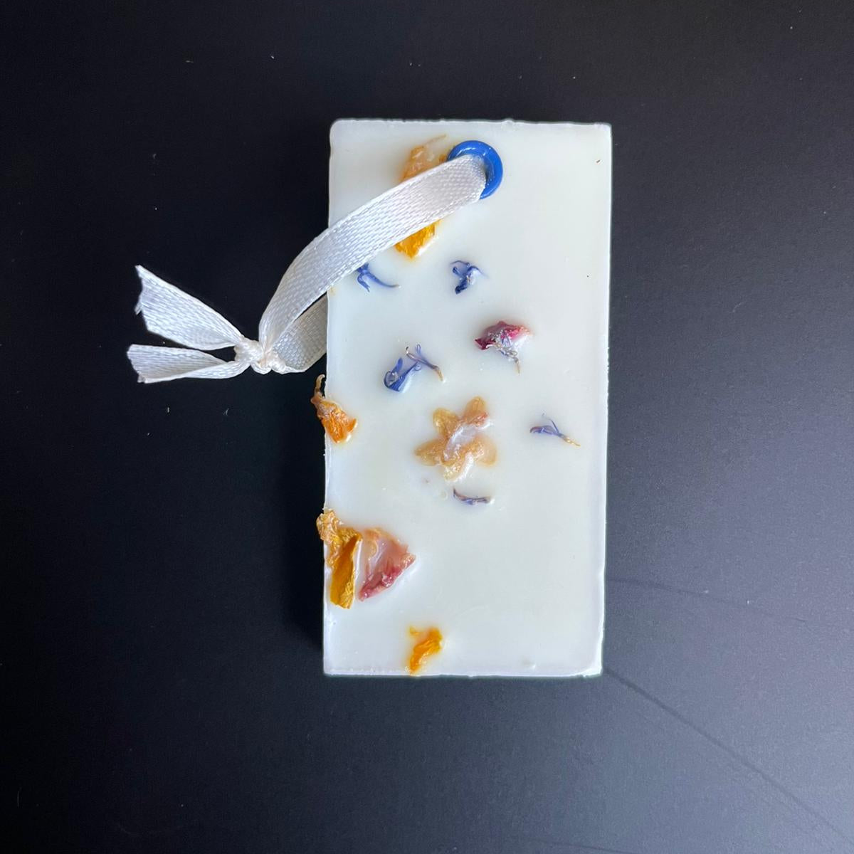 Fondant suspension Noix de Coco Divine posé sur une table, cire de soja naturelle, parfum de Grasse, fait main au centre O’Jawhar à Kaysersberg.