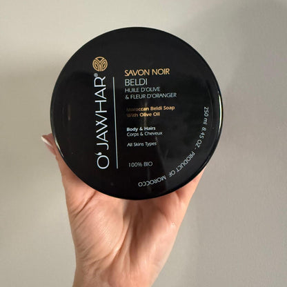 Gros plan sur l’étiquette du savon noir O'Jawhar avec liste d’ingrédients et instructions d’usage, idéal pour les clients soucieux de la composition.