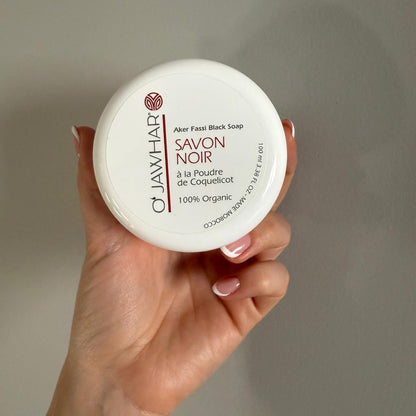 Pot de savon noir O’Jawhar tenu à la main – format 100 ml
